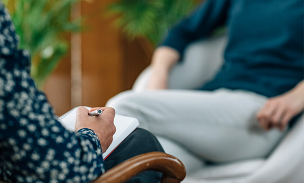 group of five young adults engaging in conversation and using devices in a casual setting promoting collaboration and teamwork in a comfortable environment