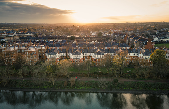 aerial view of residential area with houses along river at sunset showcasing peaceful neighborhood ambiance and scenic beauty
