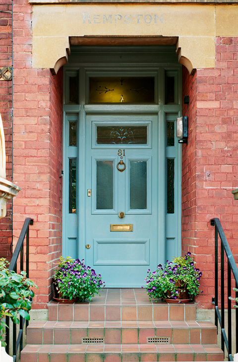 blue front door with decorative glass and potted flowers leading to a residential building 4 attractive entryways